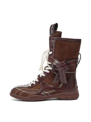Dark brown asymmetric foldover lace-up mid-calf utility boots with contrast white laces and side buckle on white background