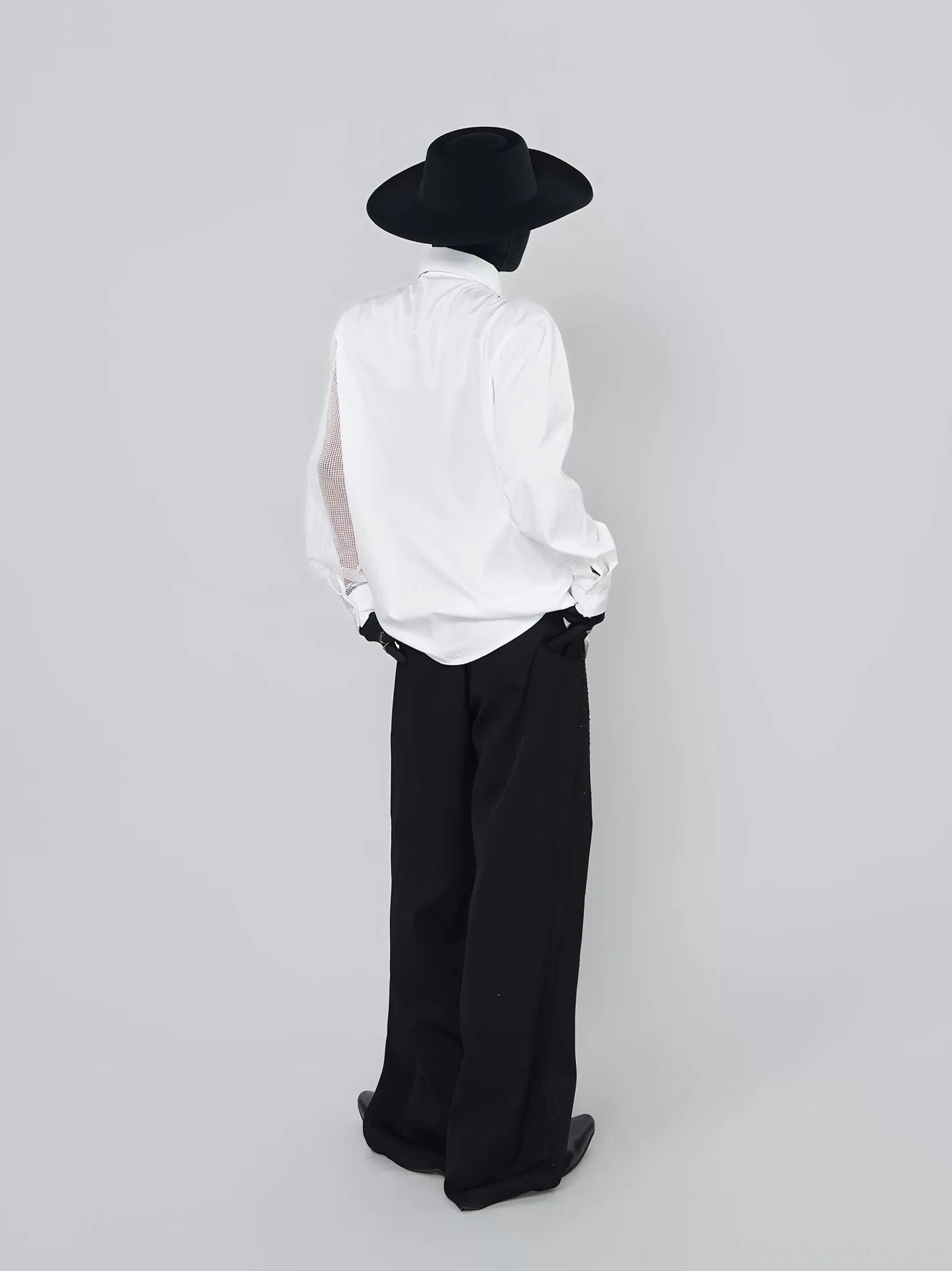 Back view of white asymmetric mesh sleeve shirt styled with black trousers in a Seoul-inspired formal streetwear look