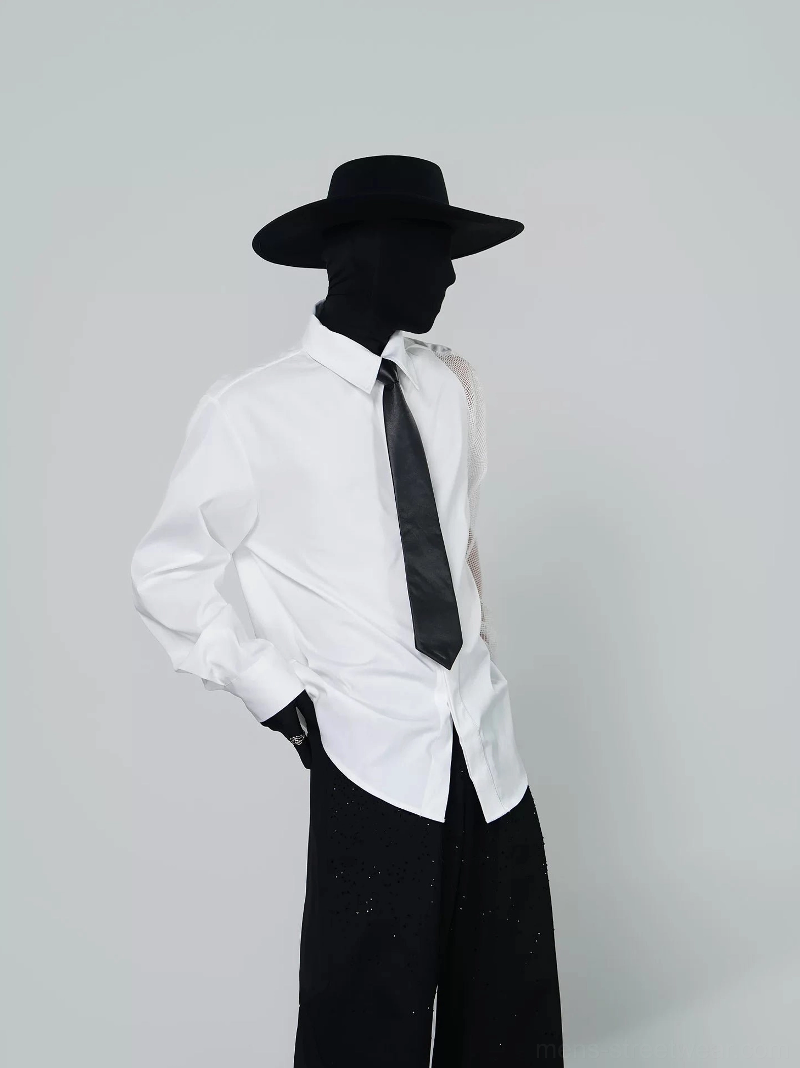 Asymmetric mesh sleeve white dress shirt with black tie shown from a three-quarter side view on a black mannequin