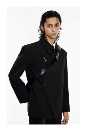 Mens asymmetrical black blazer with crossover front strap and structured shoulders shown in front three-quarter studio view