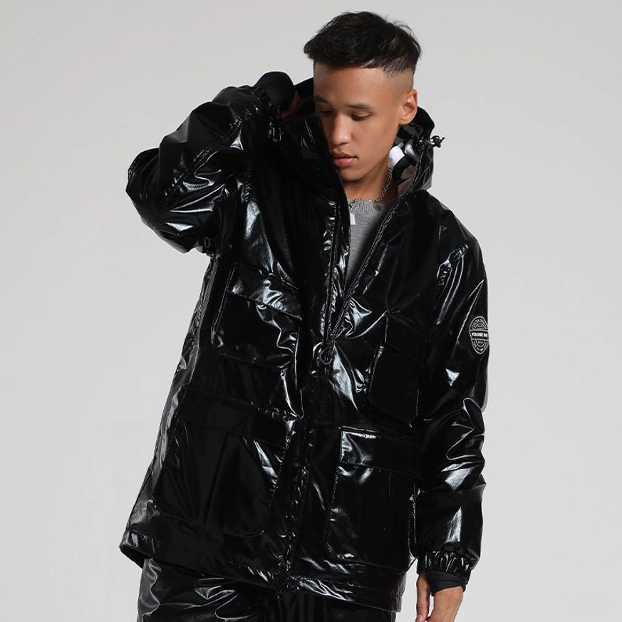 Black glossy storm shell ski jacket shown from a side three-quarter angle with cargo pockets, attached hood, embossed sleeve patch, and windproof ribbed cuffs