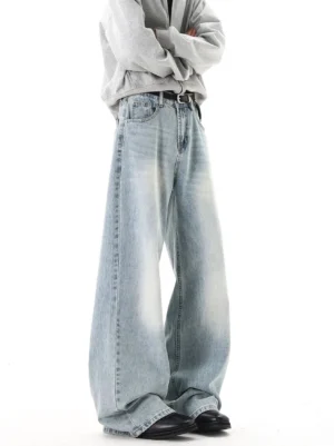 Side angle view of light blue vintage wash wide-leg jeans showing relaxed drape, black belt, and stacked leg opening