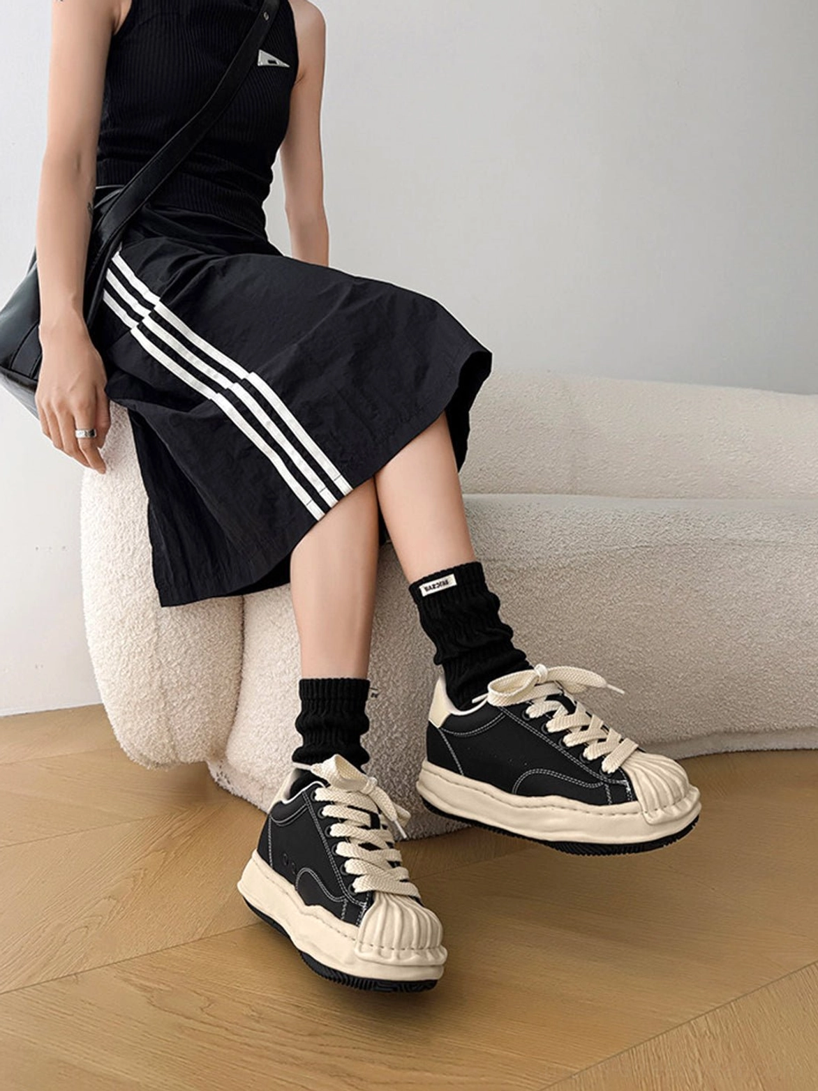 Avant-garde inspired black platform sneakers with distressed panels, padded collar, and rounded toe
