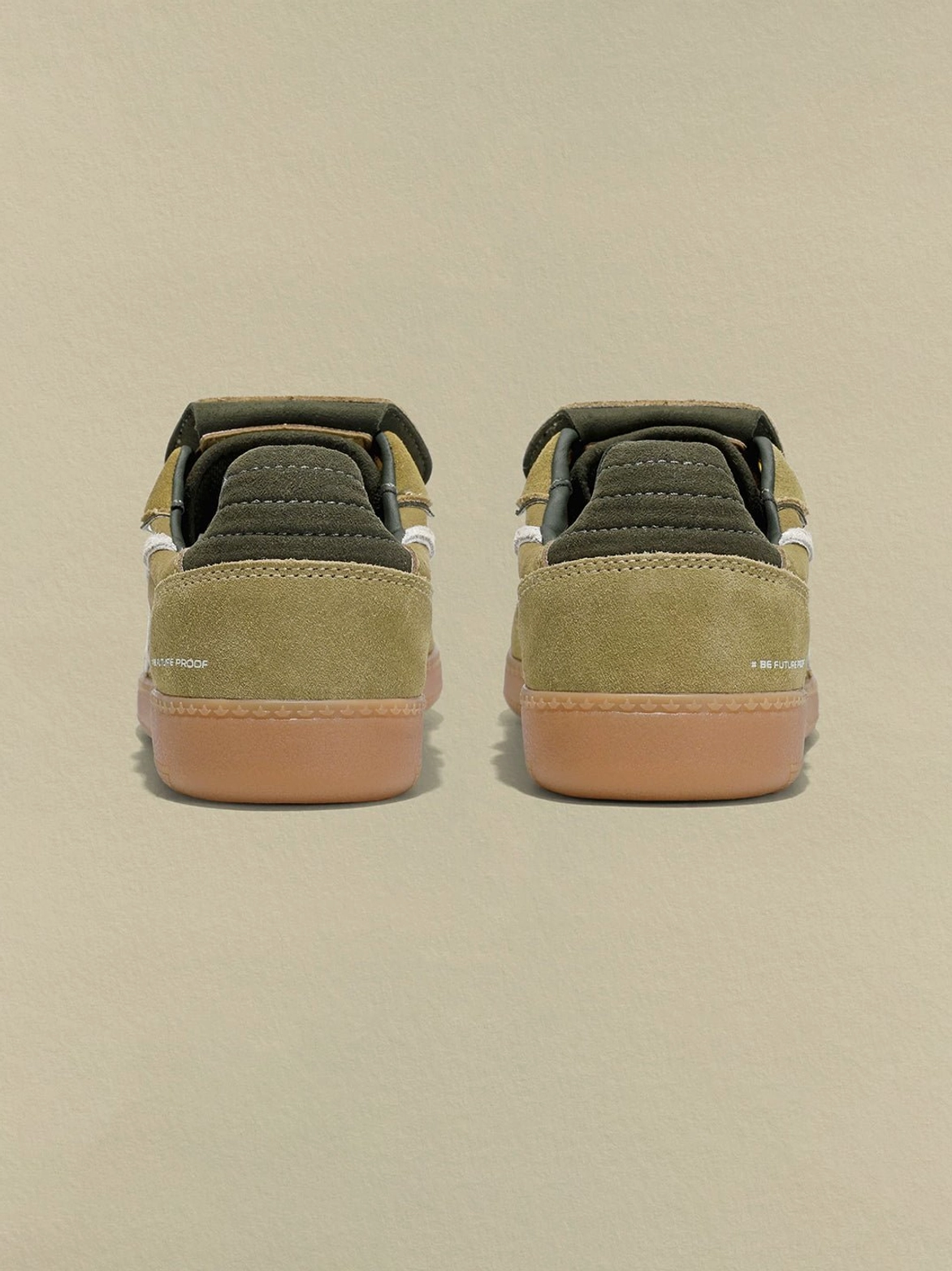 Rear view of avocado suede retro sneakers showing padded heel collars, dark green heel panels, and textured gum rubber outsoles