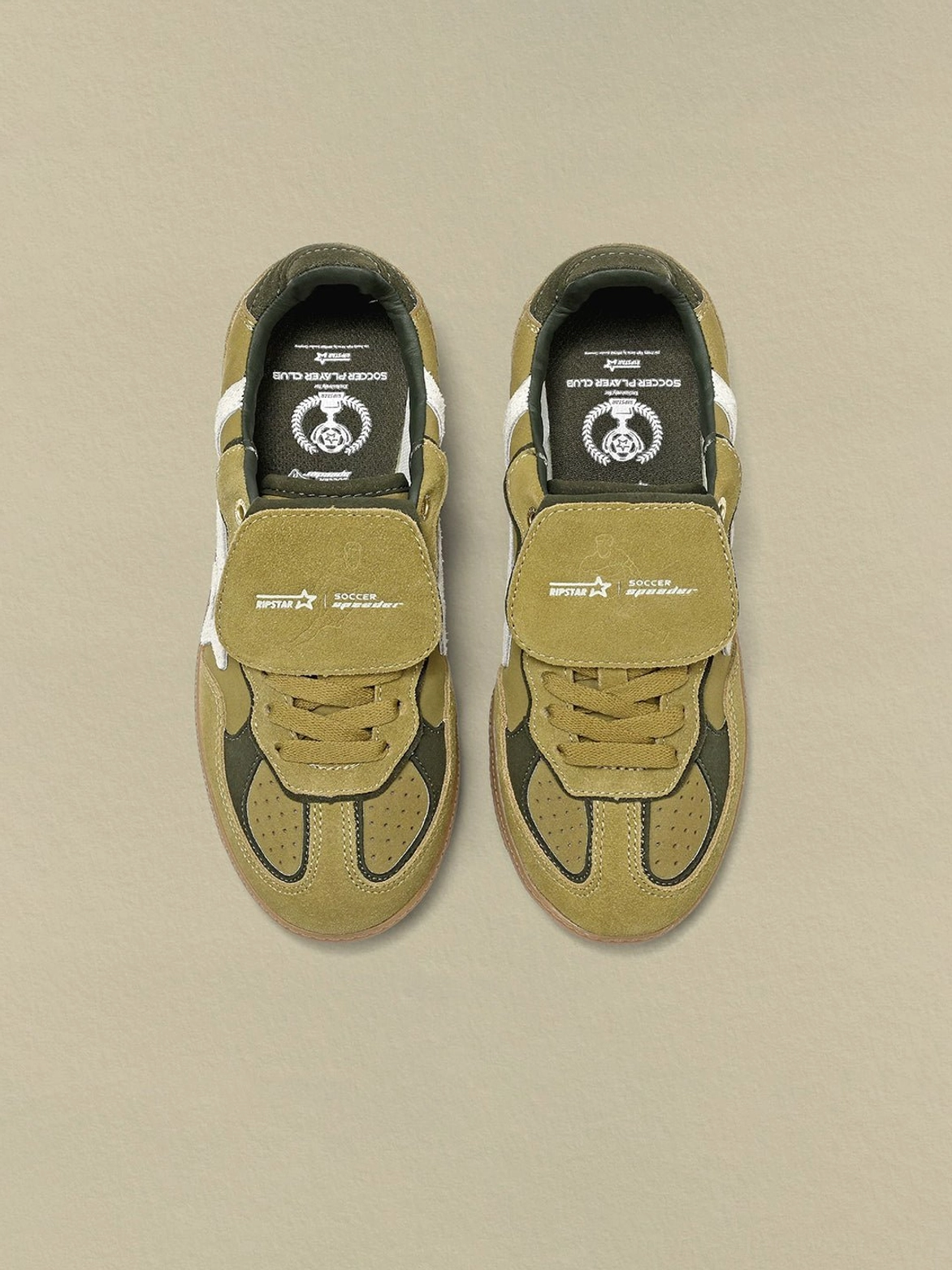Top-down view of avocado suede star-panel sneakers displaying the embroidered insole logo, detachable tongue strap, and layered upper design