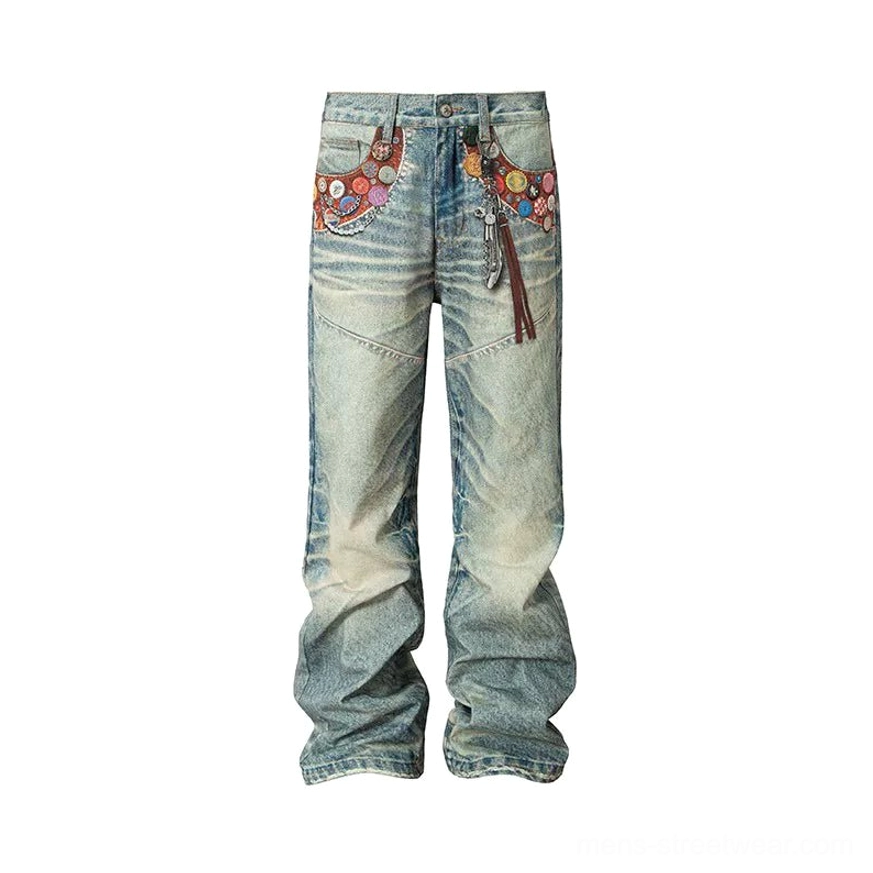 Front flat lay of light blue acid wash badge embellished wide leg jeans with tassel chain and oversized silhouette