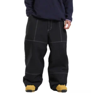 Black baggy snowboard pants with bold white contrast stitching and wide-leg streetwear fit styled with a navy sweatshirt and casual shoes