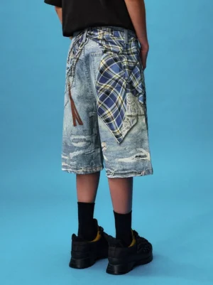 Back view of baggy washed blue denim jorts worn with black streetwear outfit, plaid waist accent, chains and chunky sneakers