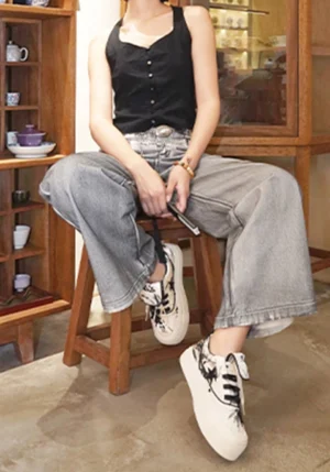 Bamboo star ink wash canvas sneakers worn with grey wide-leg jeans in a traditional East Asian inspired interior