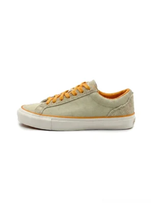 Single beige colorblock suede skate shoe with bright orange laces, orange piping trim, white rubber outsole, and low-top streetwear silhouette