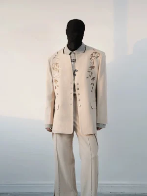 Full front view of a beige embroidered stand collar blazer and matching flared trouser suit for modern mens streetwear