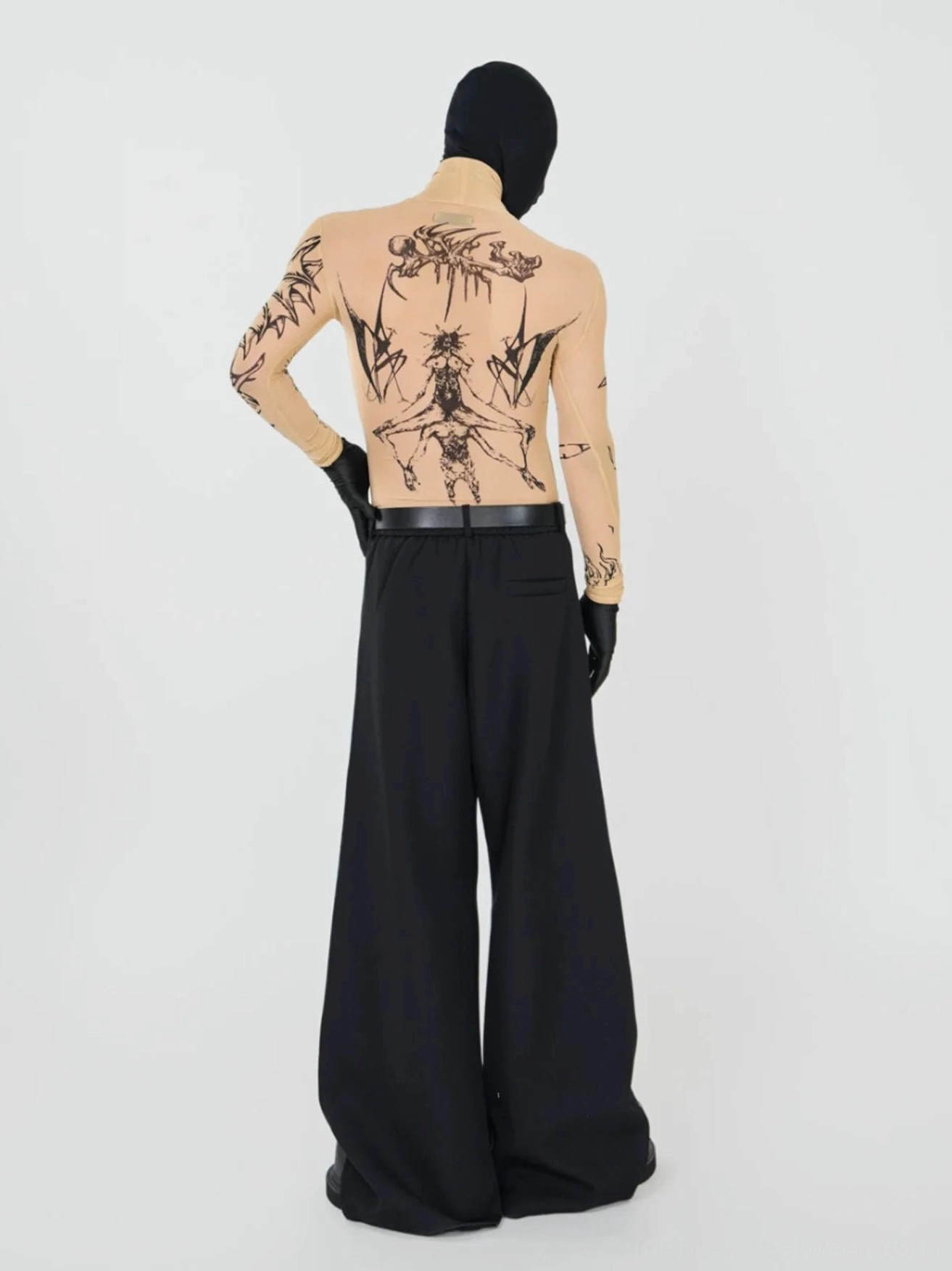 Back view of beige nude-tone sheer gothic tattoo mesh top with graphic artwork across the back and long sleeves