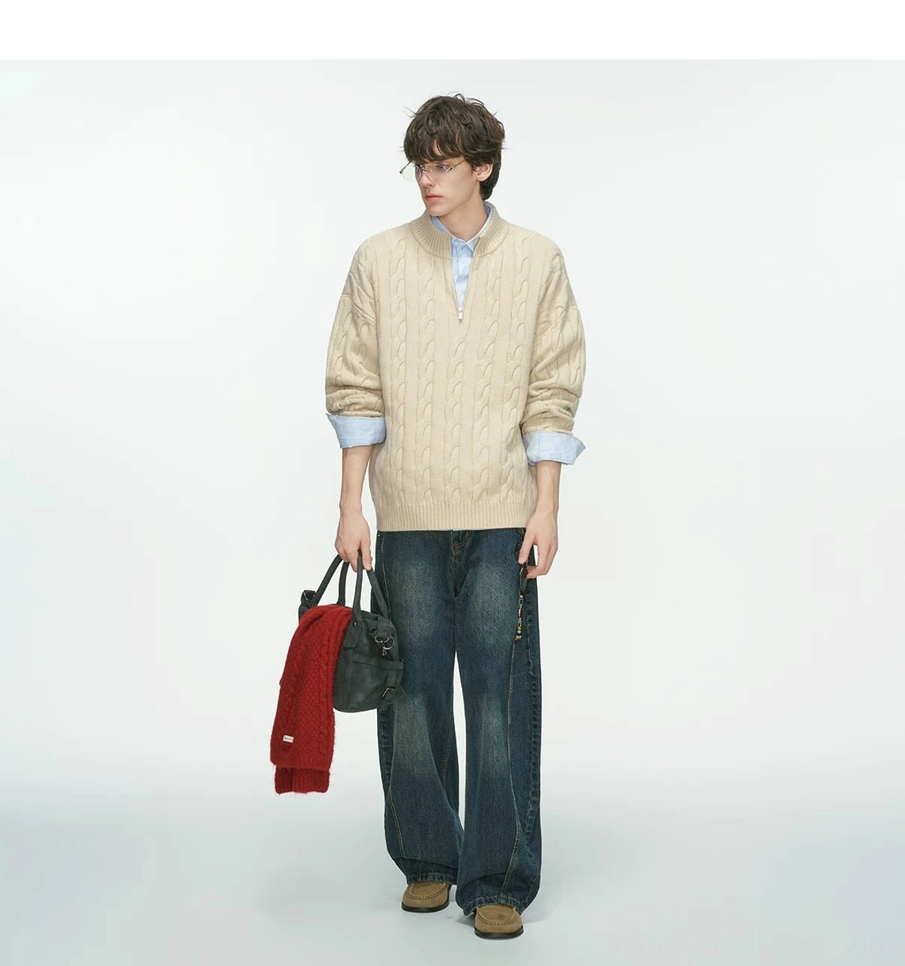 Beige oversized cable-knit half-zip sweater styled with dark blue wide-leg jeans and a black red tote bag
