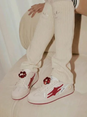 Unisex beige and red retro streetwear sneakers styled with cream ribbed trousers and tall socks in a relaxed casual outfit