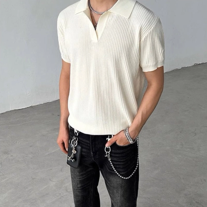 Cream beige ribbed knit polo shirt with V-shaped open collar and short sleeves styled with black jeans and chain accessories
