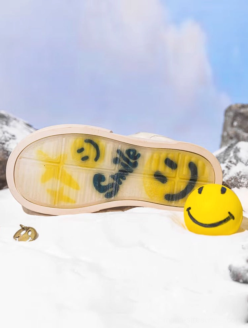 Bottom view of beige platform sneaker outsole with translucent rubber, smiley face graphics, star motifs, smile lettering, and beige rubber edging