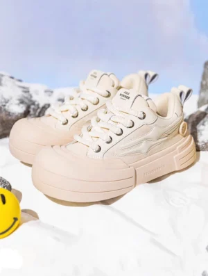 Pair of beige chunky platform sneakers shown from a front three-quarter angle with cream textile uppers, matching laces, smile streetwear styling, and subtle star details
