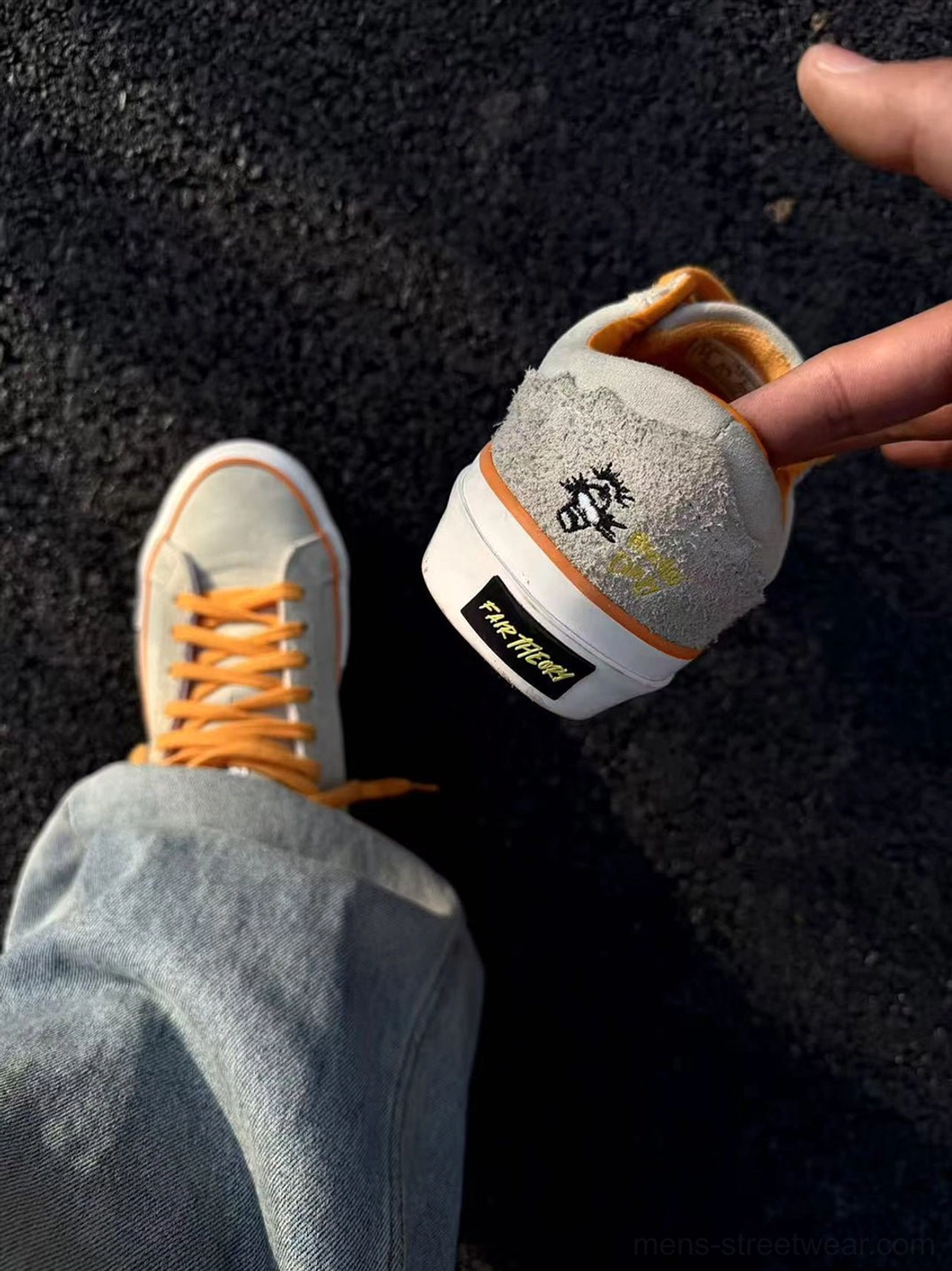 Close-up of beige suede skate shoe showing textured upper, orange heel detailing, and contrasting rubber outsole
