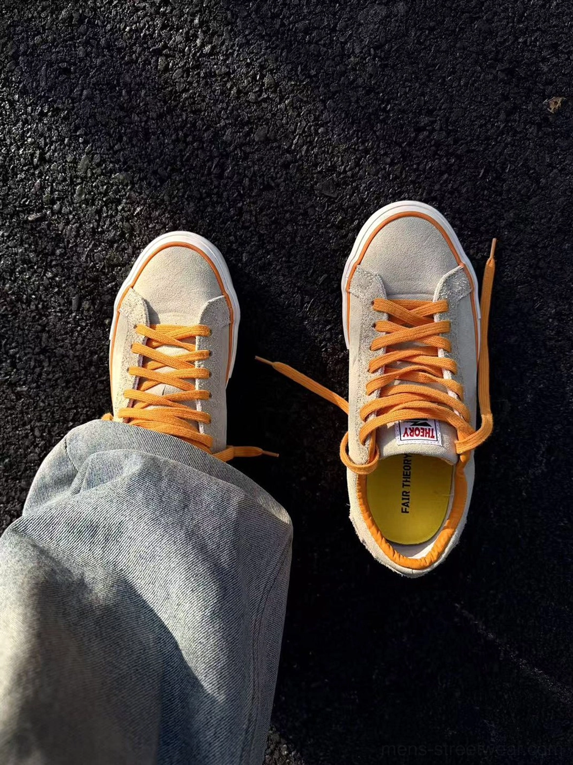 Beige orange-laced suede skate shoes worn with loose light blue jeans in an overhead streetwear outfit view