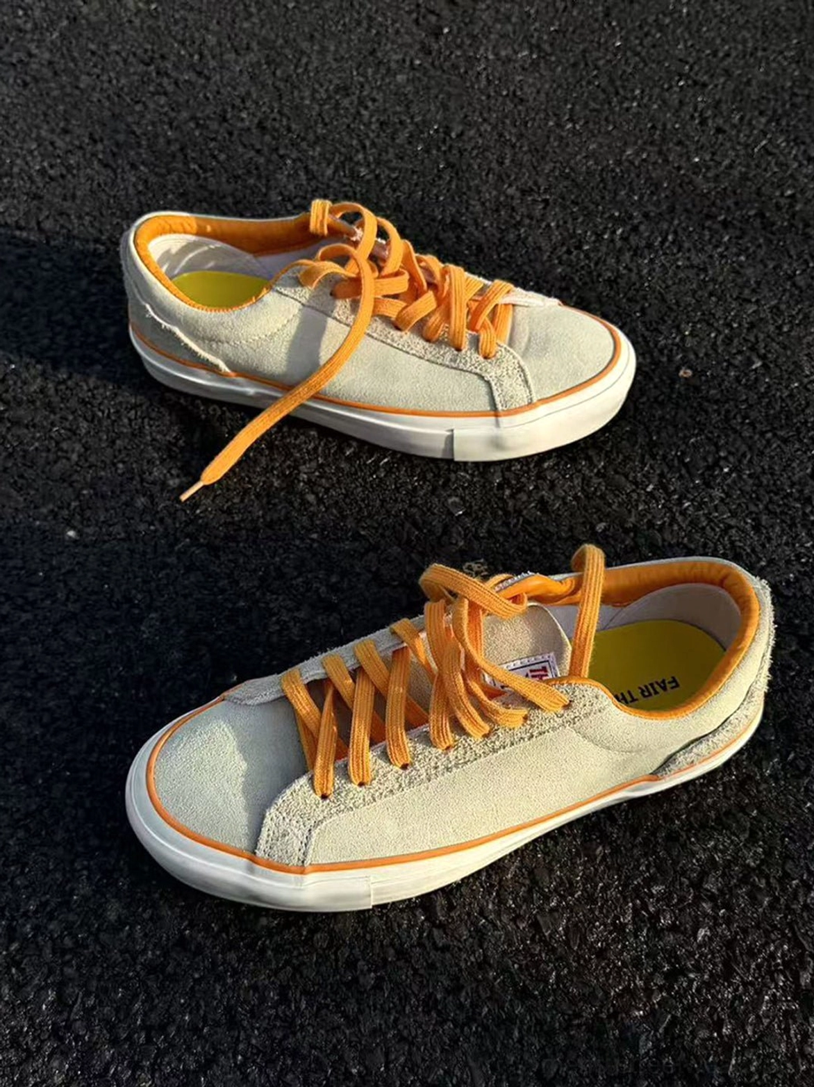 Angled flat lay of beige suede skate shoes showing orange inner lining, soft suede material, and low-top streetwear design