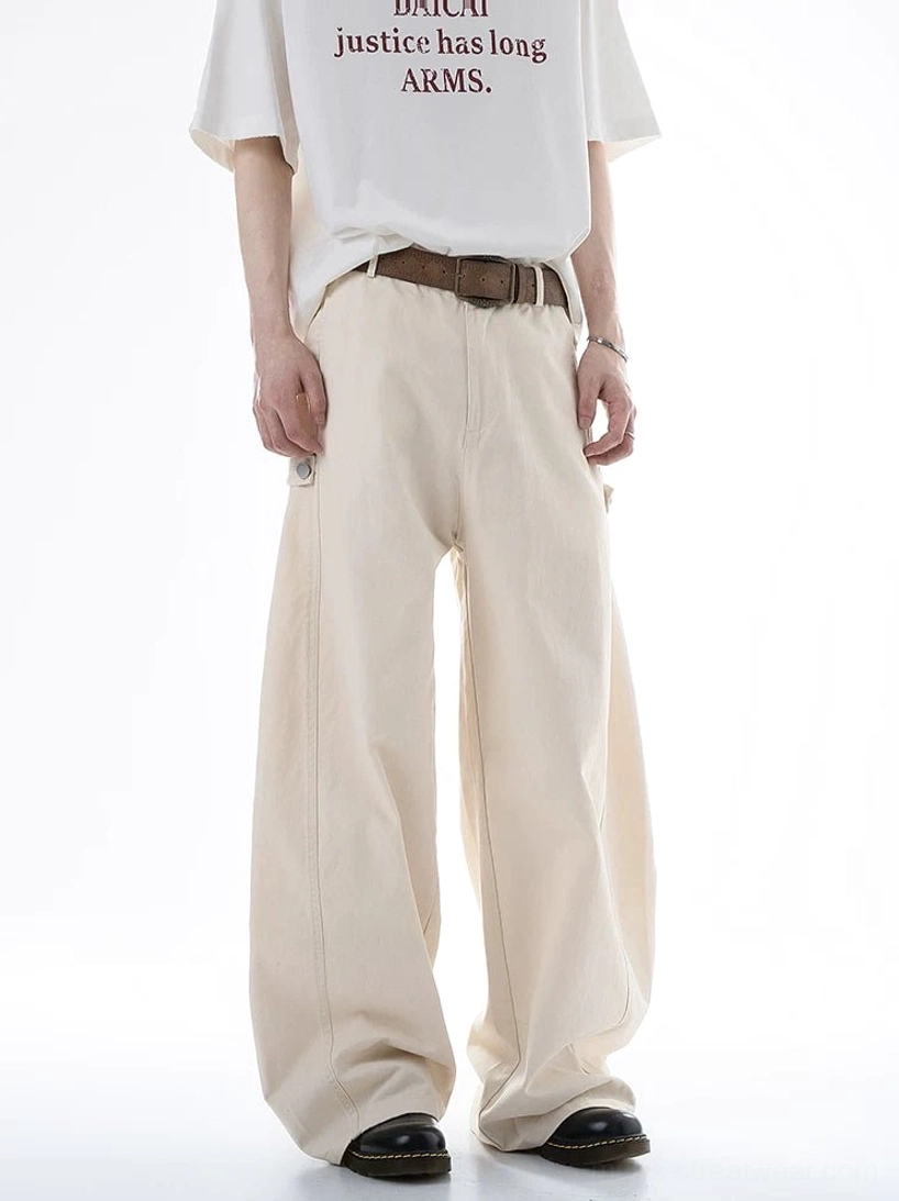 Beige ultra wide-leg cotton cargo pants shown from a front three-quarter angle with a structured drape, brown belt styling, clean neutral finish, and side cargo detail