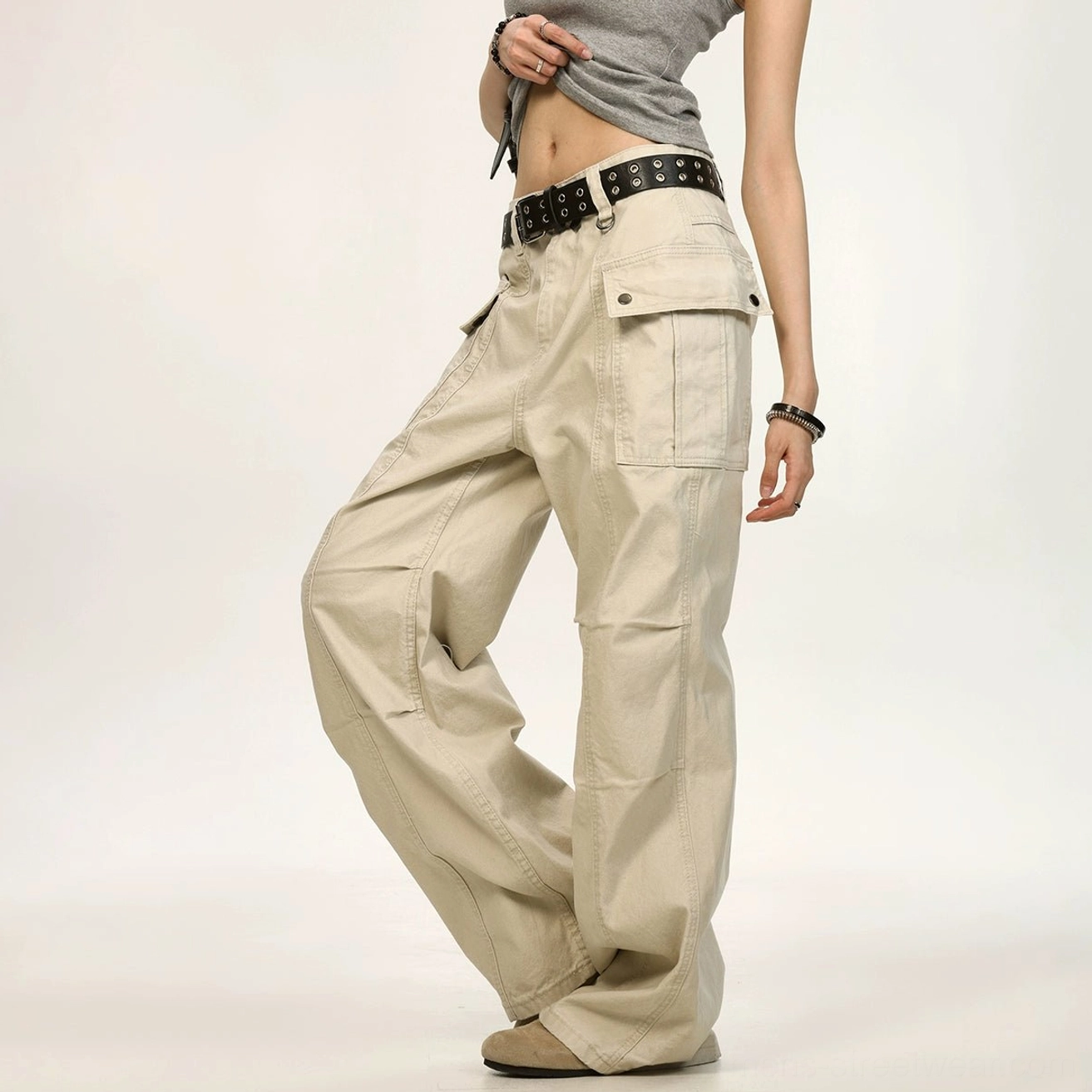 Beige washed canvas wide leg cargo pants angled view with oversized side pockets and tailored knee seams
