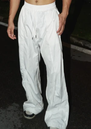 Beige wide leg carpenter work pants with elastic drawstring waist and full-length relaxed streetwear silhouette