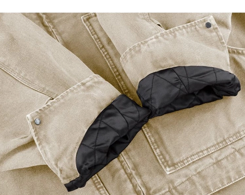 Beige utility work jacket sleeve close-up showing adjustable button cuff and black diamond quilted lining at the turned-back sleeve