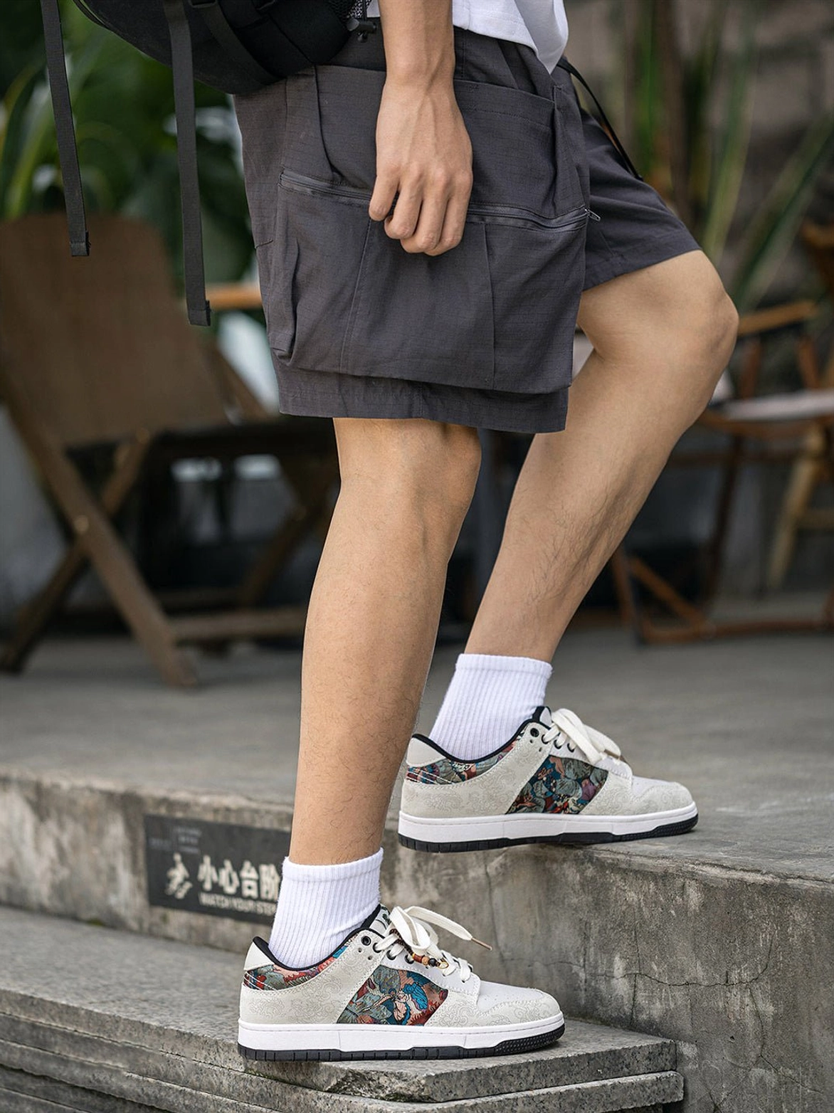 Bird embroidered brocade court sneakers worn with cargo shorts and white socks in a Korean-inspired streetwear outfit