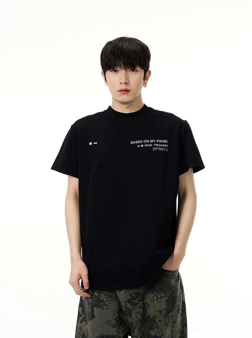 Black Acid Techno graphic tee styled with camo cargo pants, featuring tech-inspired chest artwork and asymmetric seam detail