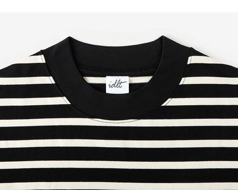 Close-up of the ribbed black crew neck collar and black apricot stripe detail on a streetwear long sleeve tee