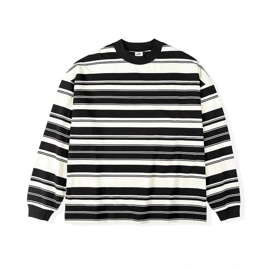Angled front view of a loose black and apricot striped cotton long sleeve tee with aligned horizontal stripes
