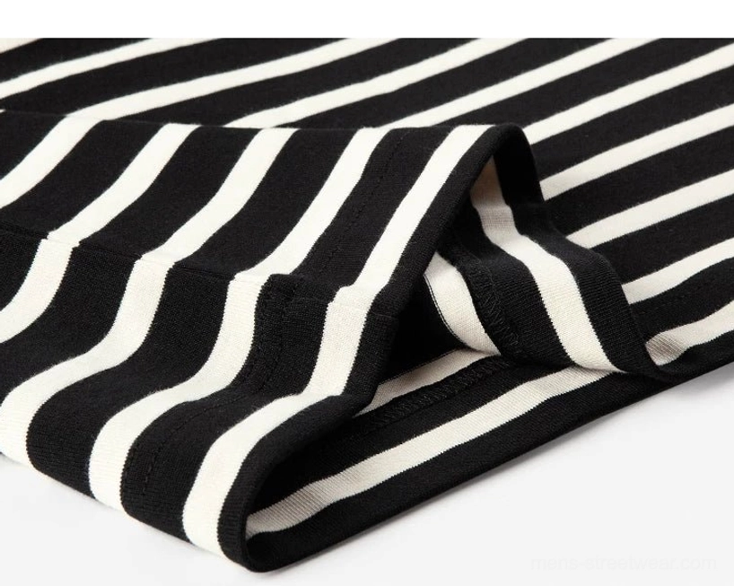 Draped fabric close-up showing the smooth black and apricot stripe contrast on a relaxed streetwear long sleeve tee