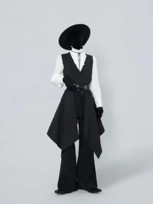 Front full-body view of black asymmetric gothic tailcoat vest with waist belt styled over a white stand-collar shirt and flared black trousers