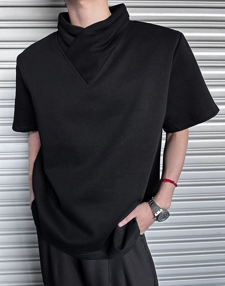 Side view of black asymmetric mock neck T-shirt showing draped folded collar, wide short sleeves, and relaxed streetwear silhouette