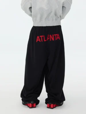 Black Atlanta graphic hyper volume baggy sweatpants rear view showing red Atlanta lettering on elastic waistband