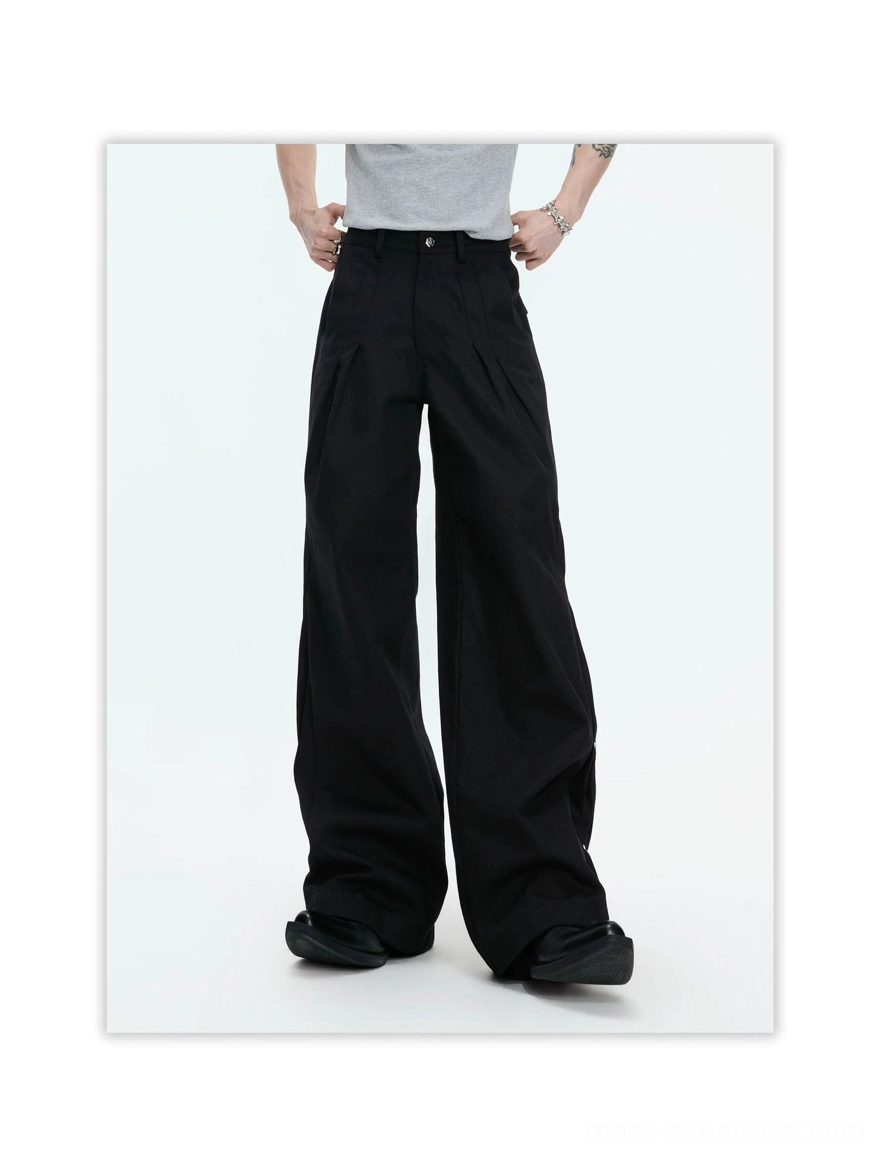 Black avant-garde draped wide leg pants front view featuring a high waist, tailored front pleats, and relaxed flowing legs