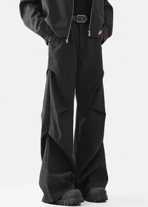 Black avant-garde wide-leg utility pants styled with a dark jacket, utility belt, and chunky streetwear work boots