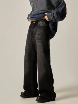 Front low angle view of black baggy straight-leg jeans with faded denim wash and wide relaxed streetwear silhouette