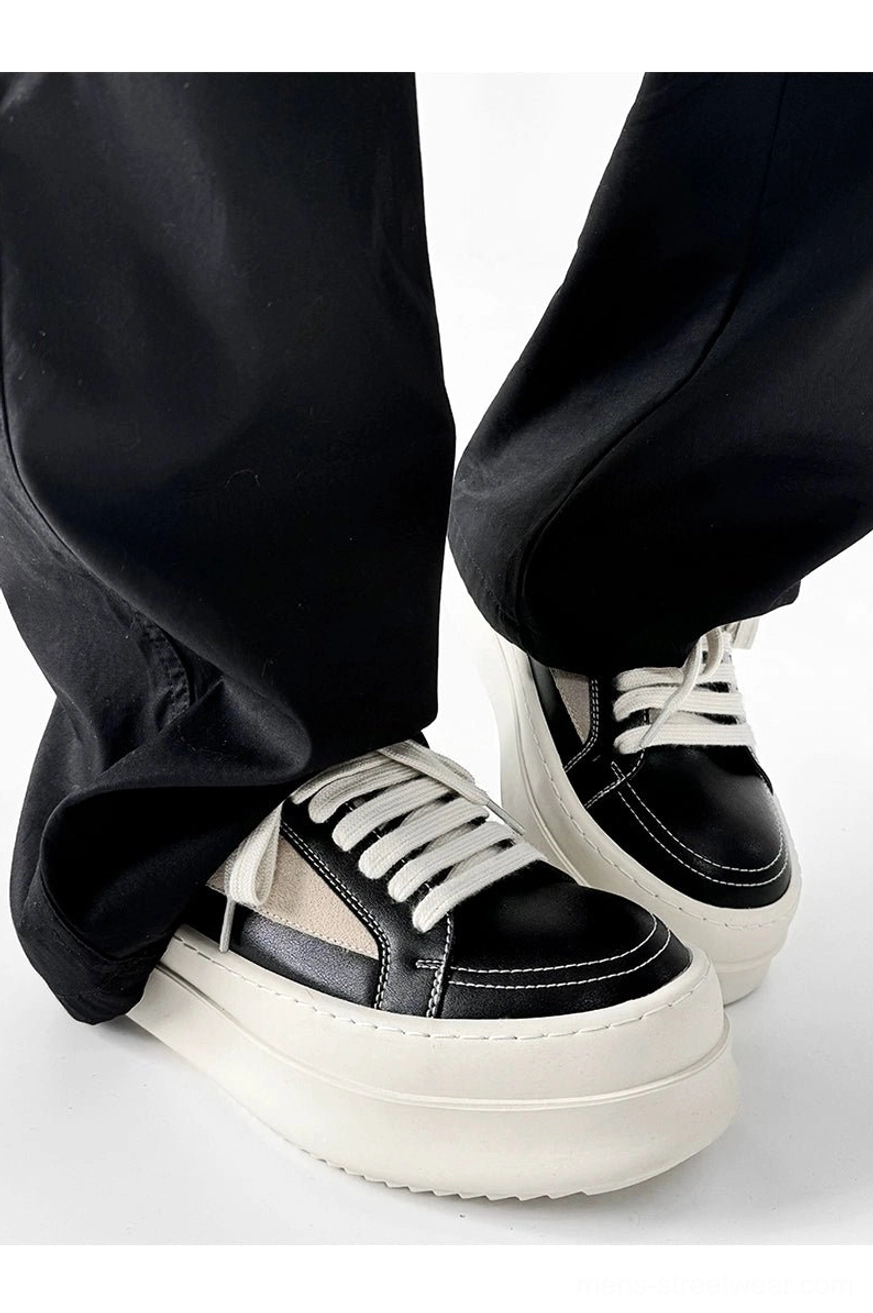 Close-up rear-side view of black and beige chunky platform sneakers with thick off-white soles