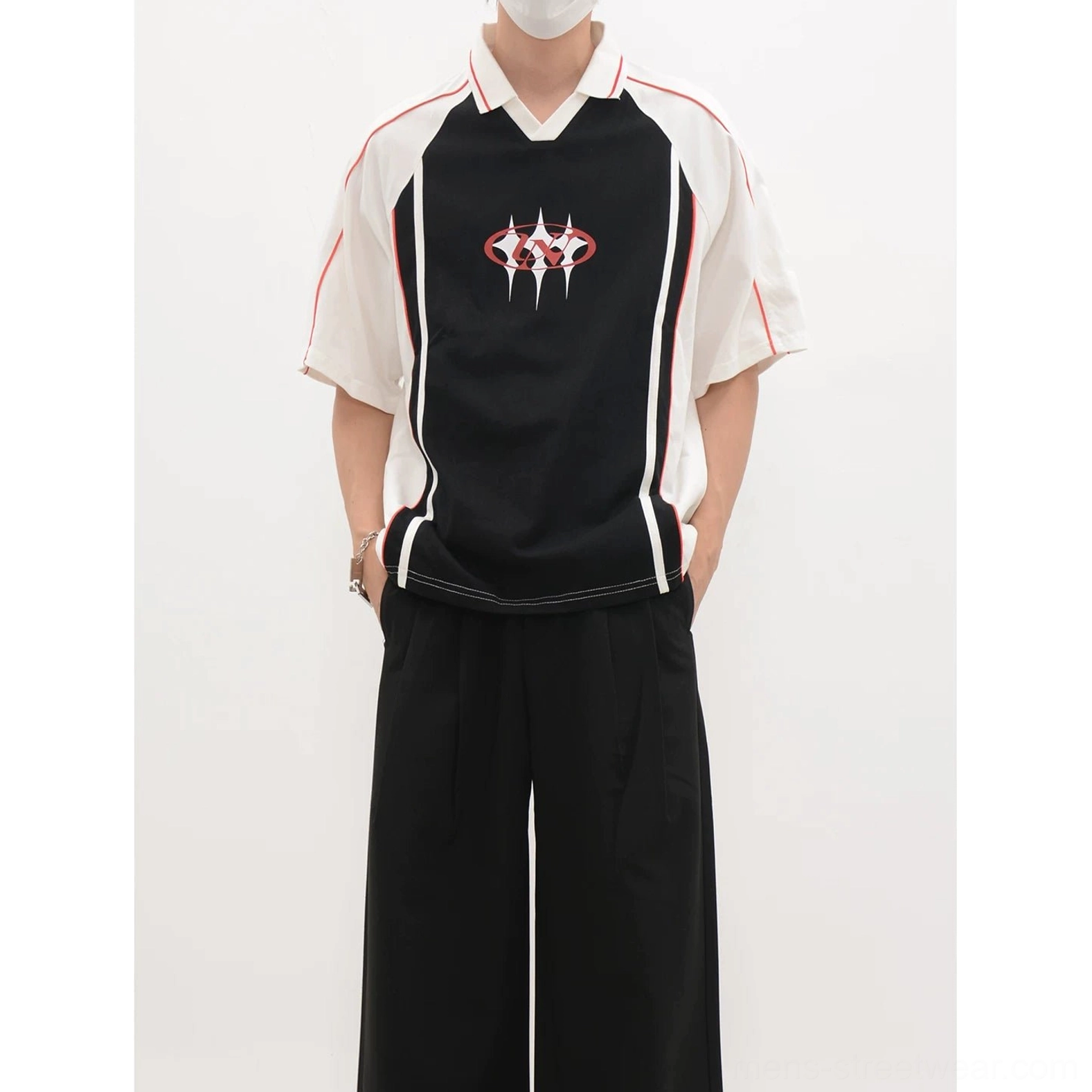 Front view of a black body polo soccer jersey with white collar and sleeves, vertical side panels, and chest crest