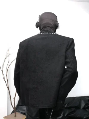 Back view of black textured boucle streetwear jacket with pearl neckline trim, structured shoulders, collarless silhouette, and raw frayed hem