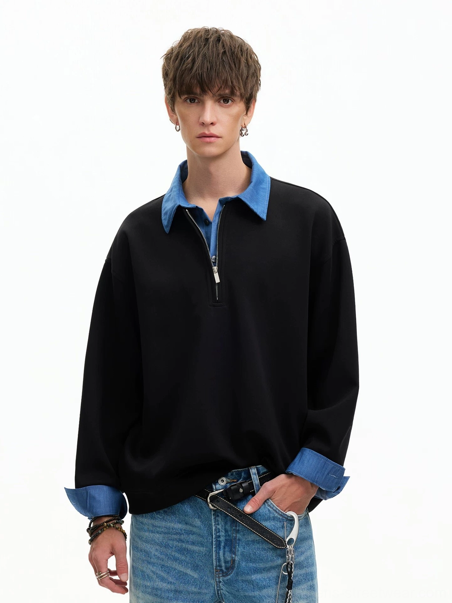 Three-quarter view of black relaxed boxy half-zip sweatshirt with blue contrast collar and cuffs