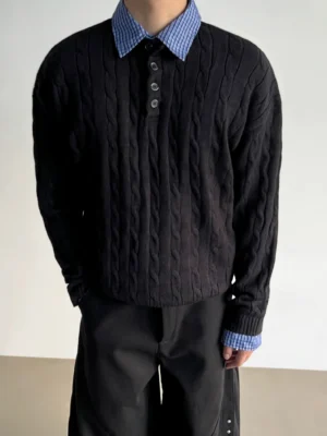 Black cable knit polo sweater with blue gingham contrast collar and layered shirt cuff details front view