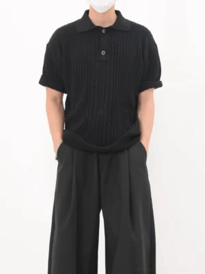 Black cable knit short sleeve polo shirt with rolled sleeves, three-button collar, relaxed Korean streetwear fit, and wide black trousers