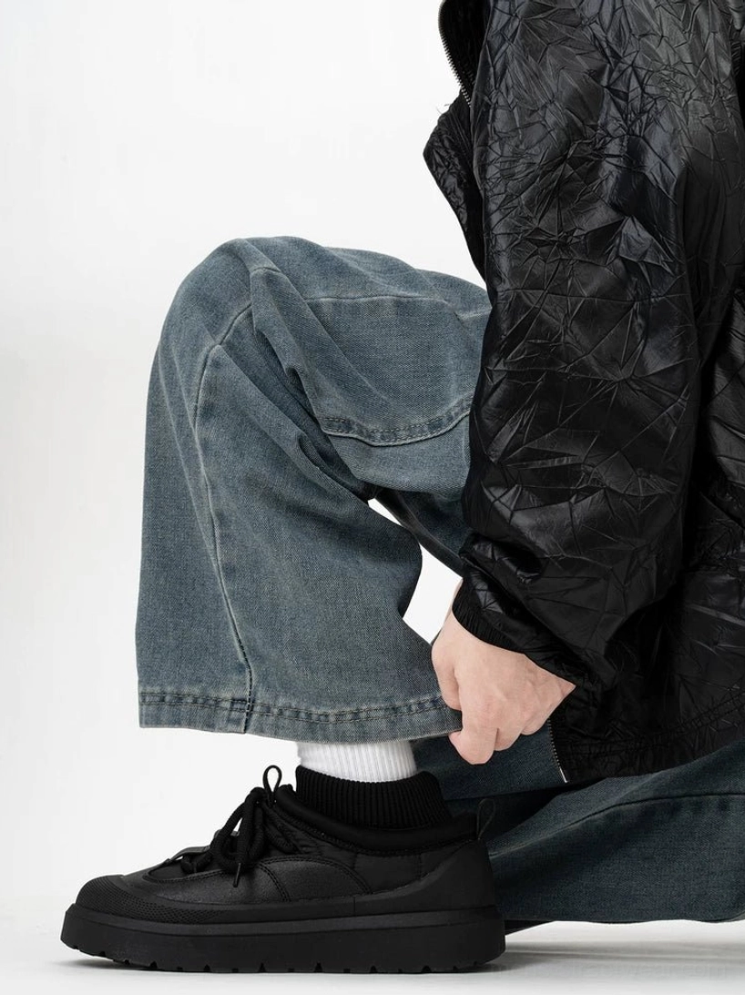 Black casual platform sneakers worn with baggy jeans and quilted outerwear, highlighting the ribbed sock collar, lace-up fastening, and non-slip outsole