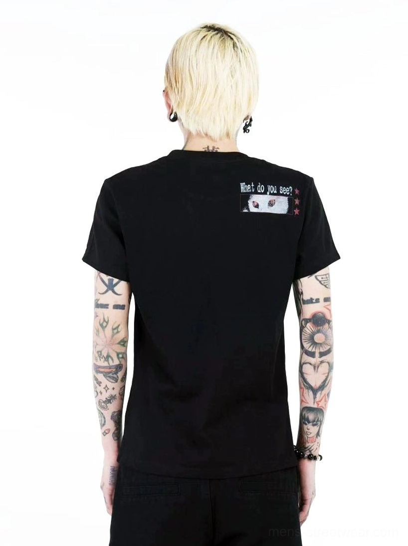 Close-up back view of black crew-neck cat graphic T-shirt showing subtle upper back slogan and small matching graphic detail