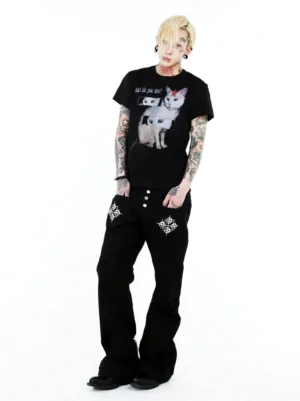 Three-quarter front view of a black cat optical illusion graphic T-shirt with white feline artwork, repeated eye panels, and What do you see slogan styled with black streetwear denim
