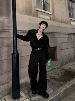 Black chain detail techwear cargo pants worn in a full urban streetwear outfit beside a street lamp