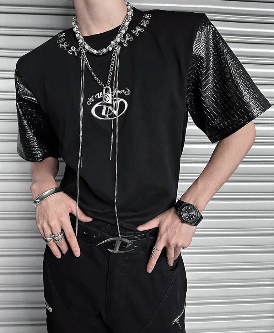 Close-up of black chain lace panel T-shirt showing crocodile-textured faux-leather sleeves, solid cotton body, and silver necklace styling